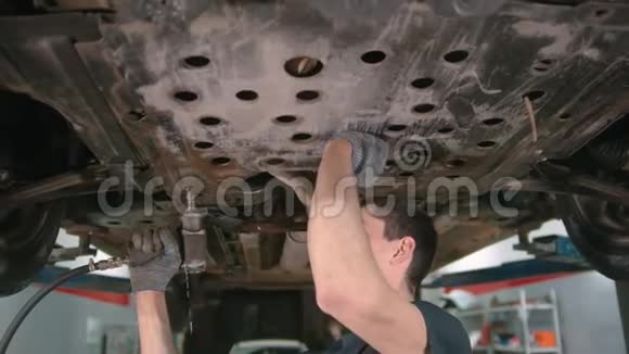 汽车修理店男子工人为进一步工作断开汽车下面的盖子视频的预览图