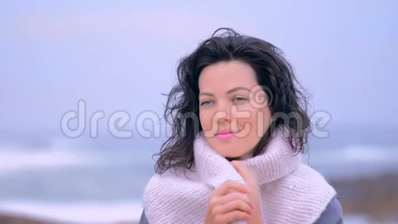 戴着白色围巾的时尚女性的肖像用呼吸温暖双手视频的预览图