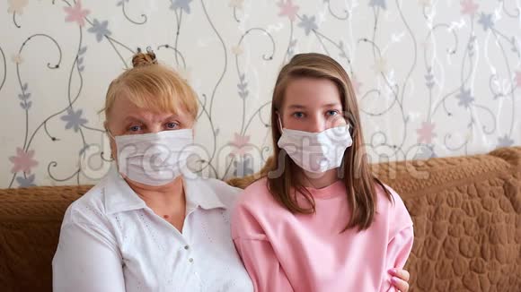 戴医疗口罩的孙女和祖母个人防护病毒和疾病视频的预览图