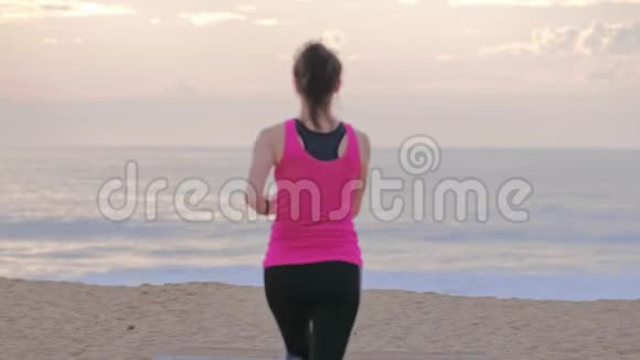 海边的女跑步者在跑步看着健身表视频的预览图