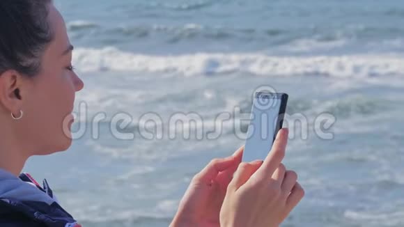布鲁内特女士在海滩上打手机聊天视频的预览图
