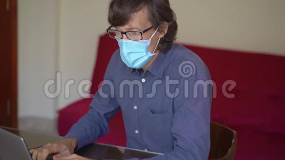 一个年轻人在冠状病毒自我隔离期间在家工作慢镜头视频的预览图