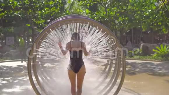 一位年轻女子在水上公园里通过圆形按摩淋浴视频的预览图