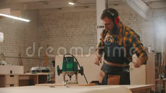 木工行业工人戴上围裙和防护眼镜开始使用磨床视频的预览图