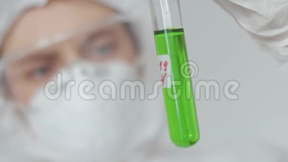 一位年轻的女科学家检查了一个带有绿色危险放射性物质的试管一个女孩视频的预览图