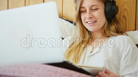 带耳机和笔记本电脑的年轻女性视频的预览图