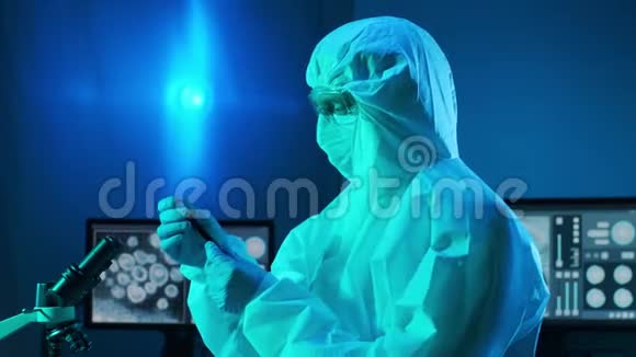 使用实验室设备在研究实验室工作的保护服和口罩的科学家显微镜试管视频的预览图