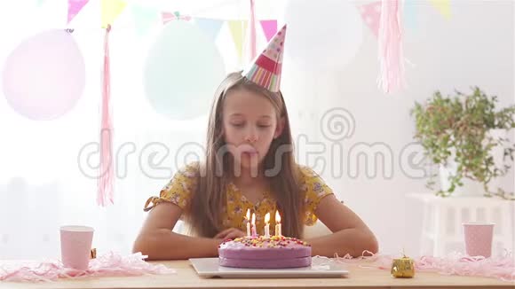 白人女孩梦幻般地微笑着看着生日彩虹蛋糕带有气球的节日色彩背景视频的预览图