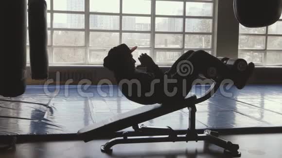 肌肉男在健身房锻炼做仰卧起坐和仰卧起坐视频的预览图