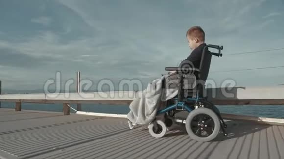 在外面坐电动轮椅的残疾男孩视频的预览图