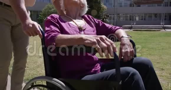 医生和一个老女人在一个养老院的公园里视频的预览图