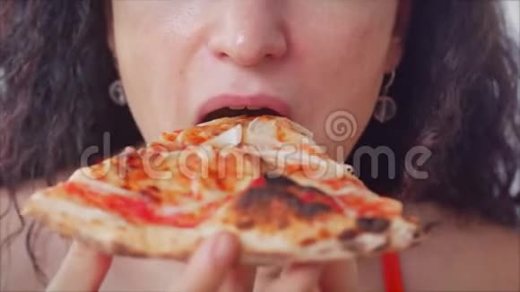 快乐放松的年轻意大利女人穿着红色连衣裙拿着一片馅饼急切地吃着意大利披萨享受着意大利披萨视频的预览图