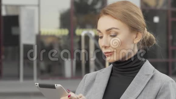 有魅力的女商人在户外使用数字平板电脑视频的预览图