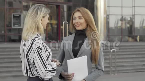 两个女商人在办公楼前握手完成交易视频的预览图