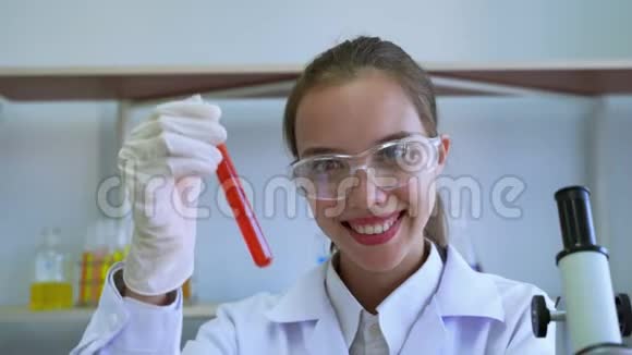 女科学家拿出试管然后在工作中自豪地微笑视频的预览图