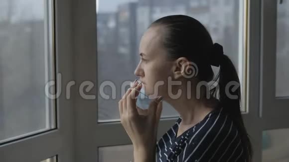 隔离生活戴防护面具的女人站在窗户边视频的预览图