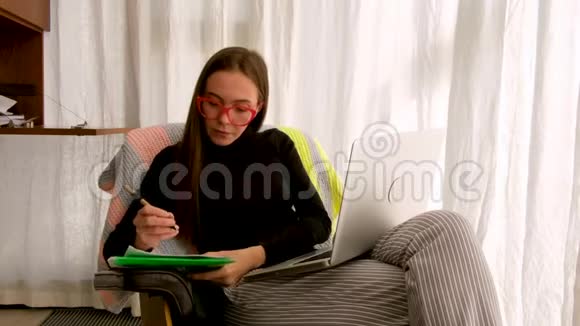 女人在家工作靠窗户的笔记本电脑视频的预览图