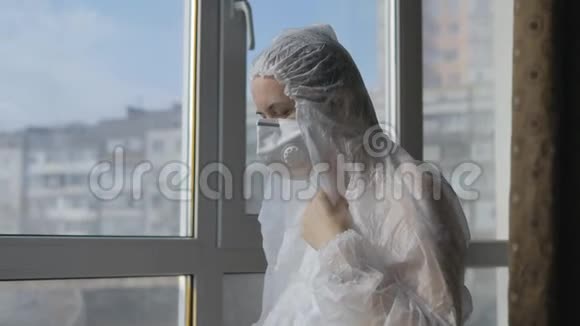 穿着防护服和防护面罩的妇女自己测量电子温度计的温度保护视频的预览图