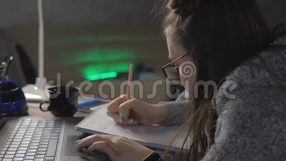 戴眼镜的少女坐在办公桌前做作业视频的预览图