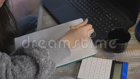 特写一个十几岁的女孩在计算家庭作业时使用计算器视频的预览图
