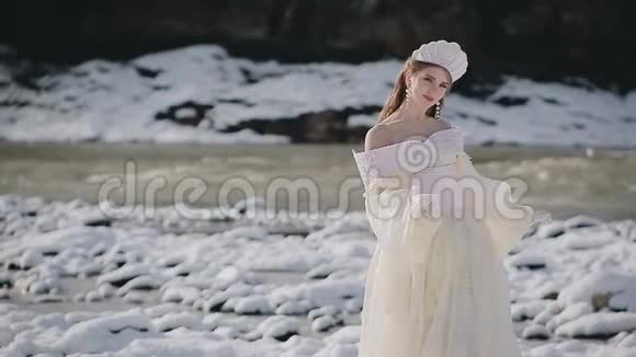 穿着白色礼服戴着皇冠站在雪地上的女人视频的预览图