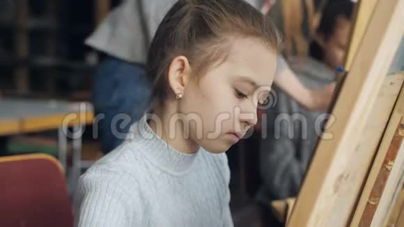 老师在美术工作室里一个小女孩讲解画画的细节视频的预览图