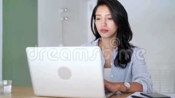 优雅的年轻商务女性在办公室里用她的笔记本电脑工作视频的预览图