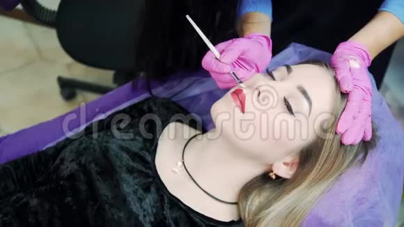 化妆师在手术前对嘴唇进行刷笔视频的预览图