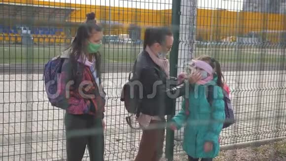 一位母亲和两个女儿戴着防毒面具在一个偏僻的地区沿街行走视频的预览图
