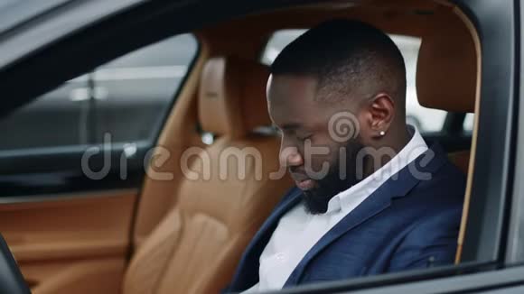 特写非洲男人在车上接电话男人在说汽车智能手机视频的预览图