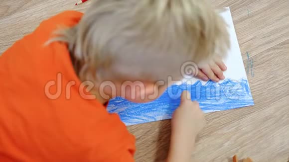 4k家里的孩子们金色小男孩的特写手在地上画夏天的黄日碧海视频的预览图