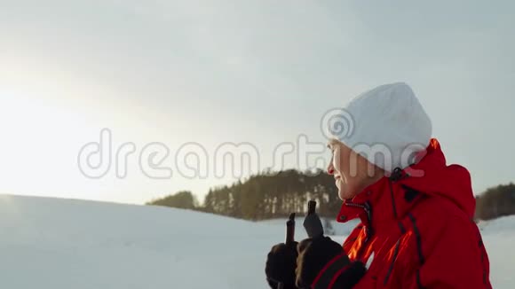 一个穿红色夹克的女人正在结冰的湖面上滑雪冬季滑雪视频的预览图