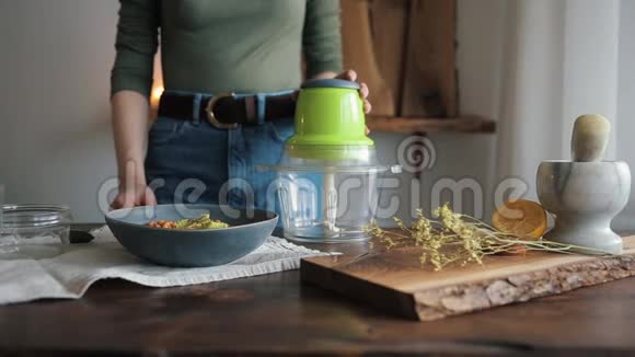 厨房餐桌上的小女孩把食材从碗里摊开用来煮传统的鹰嘴豆泥关闭视频的预览图