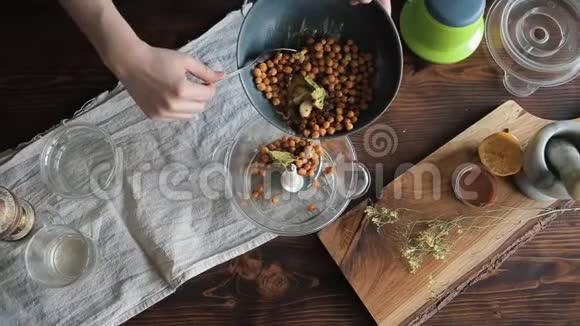 一个年轻的女孩把鹰嘴豆和其他原料从碗里放进搅拌机里做自制的鹰嘴豆特写镜头视图视频的预览图