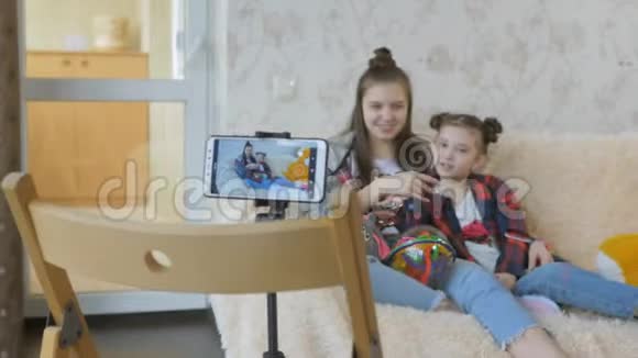 为互联网拍摄视频vlog的过程两个姐妹看着相机智能手机说了些什么视频的预览图