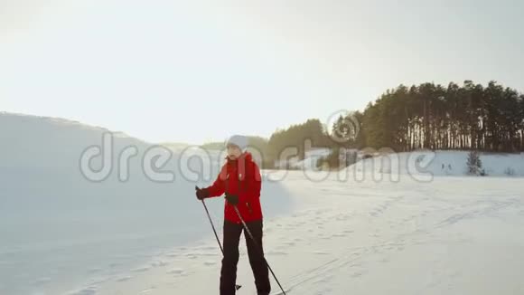 一个穿红色夹克的女人正在结冰的湖面上滑雪冬季滑雪视频的预览图