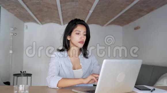 疲惫的年轻商务女性在办公室里用笔记本电脑工作时放松一下视频的预览图