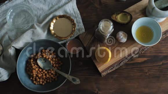 一套木制桌子上的原料用于家里烹饪传统的鹰嘴豆泥从上面看视频的预览图
