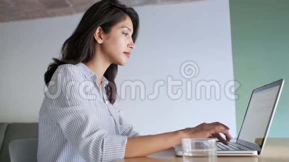 优雅的年轻商务女性在办公室里用她的笔记本电脑工作视频的预览图
