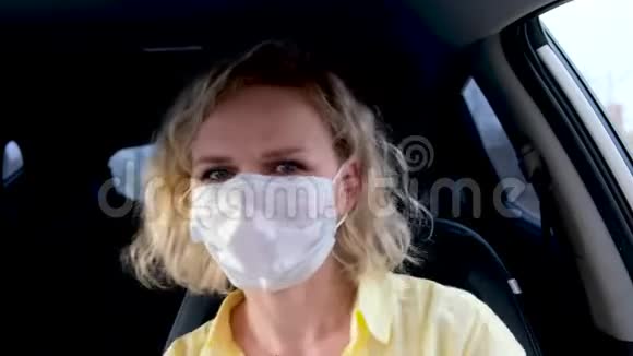 4kCurly金发女孩司机戴着医用口罩和防护手套在开车前在车上跳舞黄色夏天的女人视频的预览图