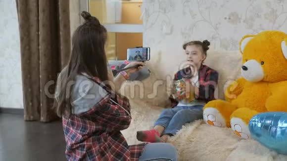 十几岁的女孩在他妹妹在沙发上玩的视频上起飞儿童博客被隔离视频的预览图