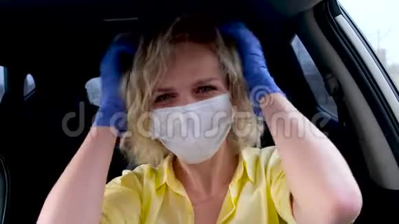 4kCurly金发女司机夏季穿戴医用口罩和防护手套在汽车前将头发扎直视频的预览图