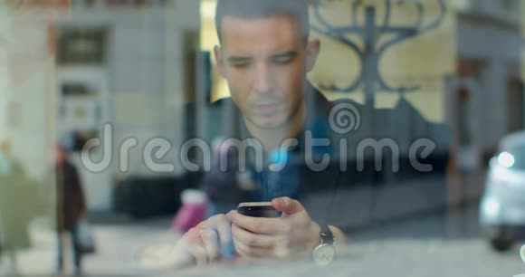 男人在咖啡馆里用智能手机喝咖啡在社交媒体上发短信享受移动技术视频的预览图
