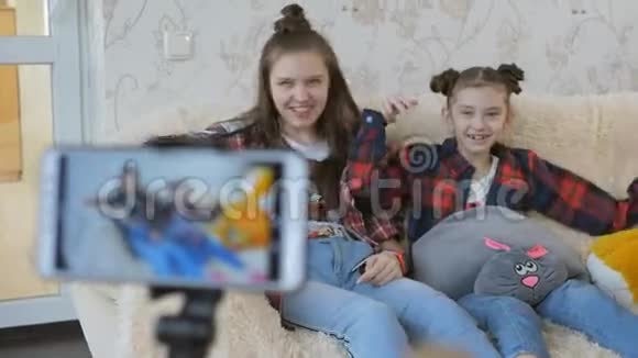为互联网拍摄视频vlog的过程两个姐妹看着相机智能手机说了些什么视频的预览图