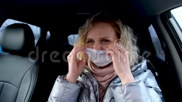 柯利金发女孩司机在开车前戴上医疗面罩和蓝色防护手套温暖的女人视频的预览图