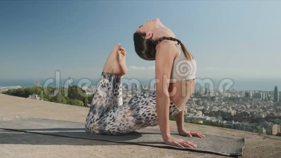 女人在户外伸展身体从巴塞罗那的角度练习瑜伽视频的预览图