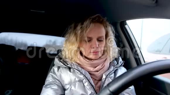 4kCurly金发女孩司机在开车前戴上两个医疗面罩和蓝色防护手套温暖的女人视频的预览图