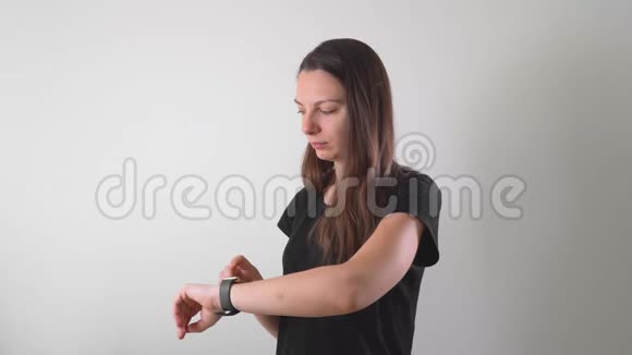 年轻女子在工作室使用她的智能手表与全息图延伸现实AR准备好了视频的预览图