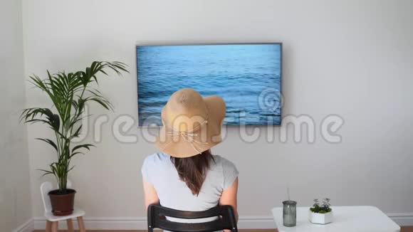家里的女人假装在海滩上电视屏幕2020年夏季检疫旅行呆在家里视频的预览图