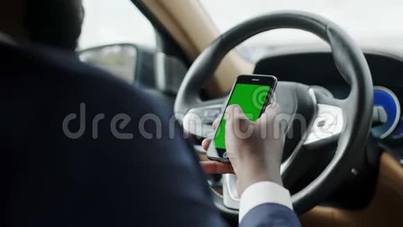 后视图男子使用手机与绿色屏幕男子打字智能手机汽车视频的预览图